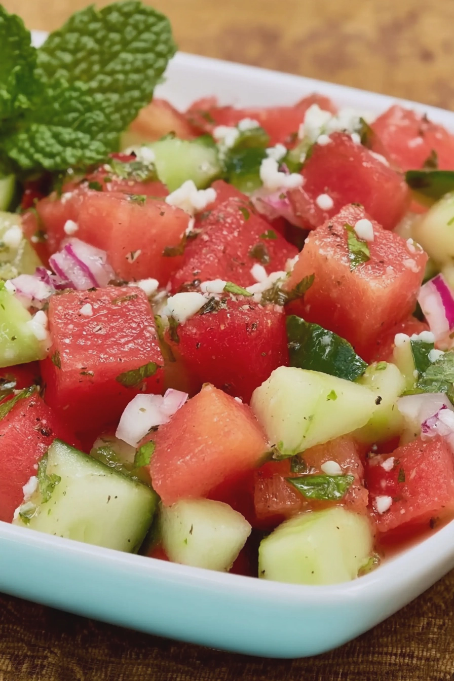 Erfrischender Melonensalat mit Minze und Limette, serviert auf einem Holztisch.